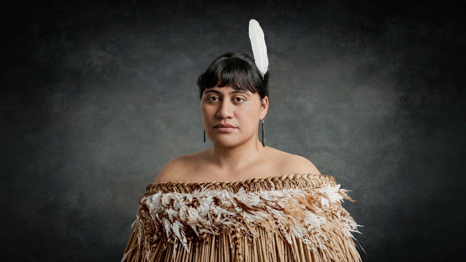 Portrait of Makuini Tuahangata wearing a korowai and white feather