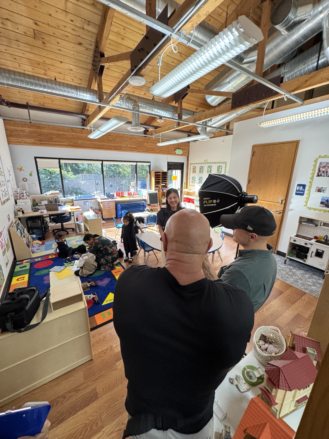 Media team filming with a teacher and young students in a classroom