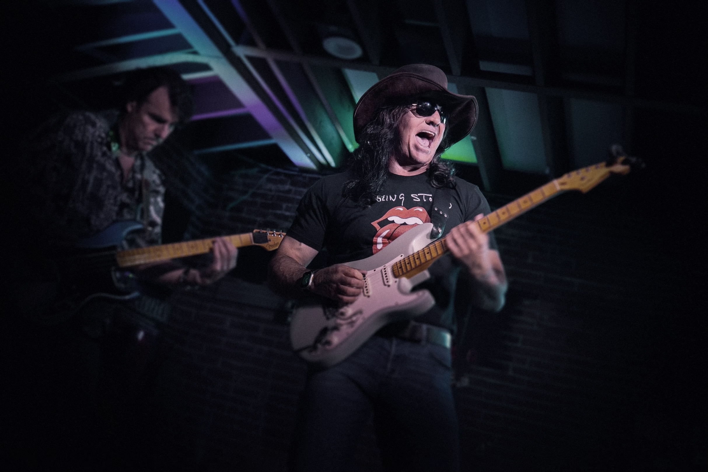 Guitarists performing together on a small stage