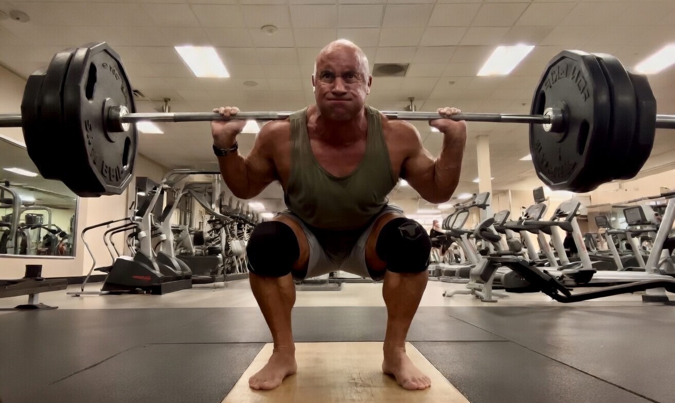 Rodger performing a barbell squat in the gym while rebuilding the lift after a knee injury